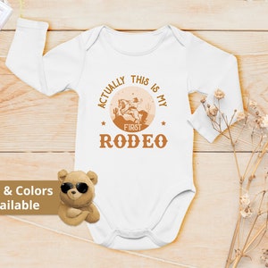 Actually This Is My First Rodeo Bodysuit Cute Cowboy & Cowgirl Pregnancy Announcement Shirt horse Rodeo Gift Yeehaw Tee 839 Bodysuit | Long Sleeve | White