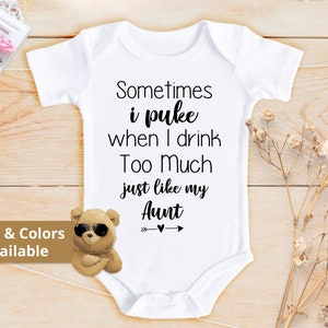 May include: White baby onesie with black text that reads "Sometimes I puke when I drink too much just like my Aunt". A brown teddy bear with sunglasses is in the bottom left corner. The text "Sizes & Colors Available" is in the bottom left corner.