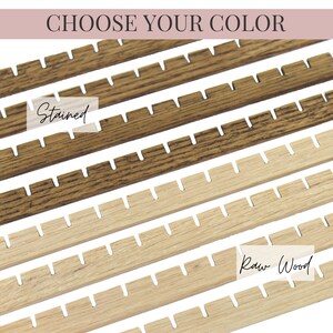 May include: Close-up of six wooden strips, showing two different finishes. The top four strips are stained a dark brown colour, with the text "Stained" written on the second strip from the top. The bottom two strips are a light natural wood colour, with the text "Raw Wood" written on the second strip from the bottom.