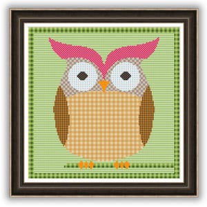 May include: Framed cross-stitch art featuring a whimsical owl. The owl has a brown and tan body, pink ear tufts, and large blue eyes. The background is a light green with a checkered pattern, and the frame is dark brown.