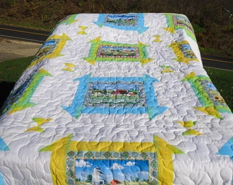 This is a new hand made queen size quilt which showcases bright outdoor farm scenes on a crisp white background.