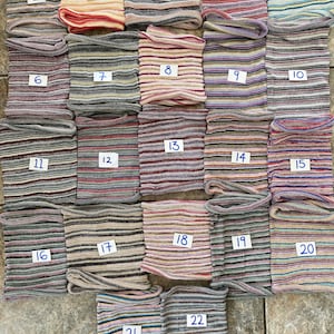 May include: Twenty-two striped fabric headbands in various colours and patterns. The headbands are numbered 1 through 22.