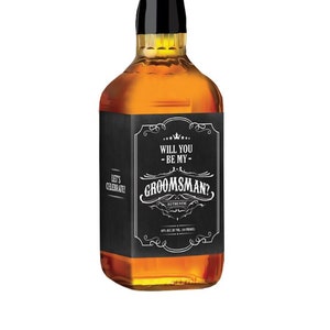 May include: A black and white label on a brown glass bottle with the text "Will you be my groomsman?" in a vintage style font.