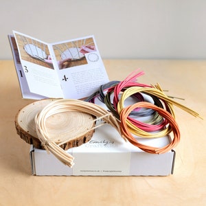 May include: A basket weaving kit with colourful reeds, a wooden base, and instructions. The kit includes a variety of colours, including red, orange, yellow, green, blue, and purple.