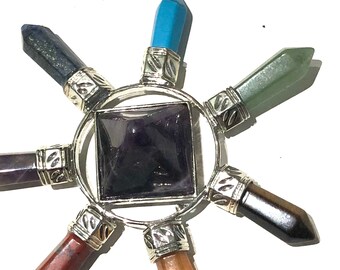 May include: A seven-pointed chakra crystal healing orgonite pyramid with a purple amethyst centre and points of blue, green, red, orange, black, and brown crystals.