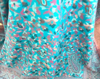 May include: A turquoise shawl with a paisley pattern in shades of pink, brown, and green. The shawl has a fringed edge.