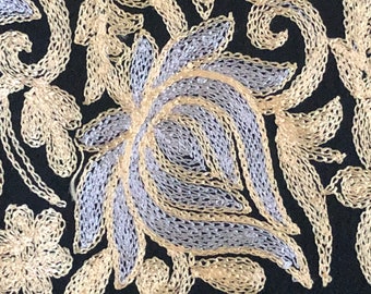 Puede incluir: Tela negra con intrincados bordados en oro y plata con un patrón floral.