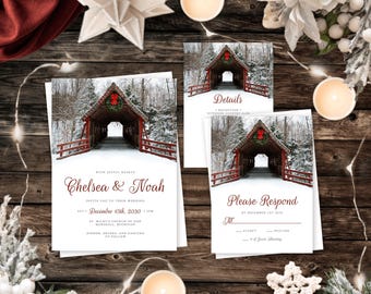 Puede incluir: Un juego de invitaciones de boda con un puente cubierto nevado y una corona roja. El texto dice Chelsea & Noah, 15 de diciembre de 2030, Details y Please Respond. Las tarjetas son blancas con tipografía en color rojo oscuro.