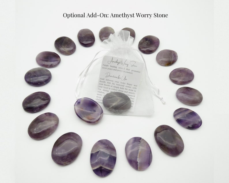 May include: A set of 12 amethyst worry stones in a white organza bag. The stones are smooth and oval shaped, with a purple and white color pattern. The bag includes a small card with information about amethyst worry stones.