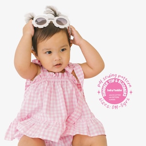 Puede incluir: Un patrón de costura para un top de verano y bloomers de vichy rosa y blanco para bebés y niños pequeños. El patrón incluye páginas de tamaño A4/US letter y está disponible en tallas 0M-5 años. El patrón se muestra en un bebé que lleva la prenda terminada.