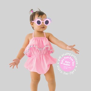 May include: A bright pink sleeveless romper featuring a ruffled bodice adorned with small multicoloured pom-poms along the edge. The text on the image reads: pdf sewing pattern, Baby Pom Pom Suit, Baby Toddler, sizes 0m-3yrs, A4/US letter, A0 file.