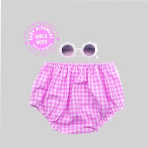Puede incluir: Unas gafas de sol de color rosa claro con forma de flor y lentes oscuras sobre unos bombachos de cuadros vichy rosas y blancos. Un gráfico circular rosa incluye el texto: pdf sewing pattern, BABY BLOOMERS, GIRLS BOYS, BEGINNER, sizes 0m-5yrs.