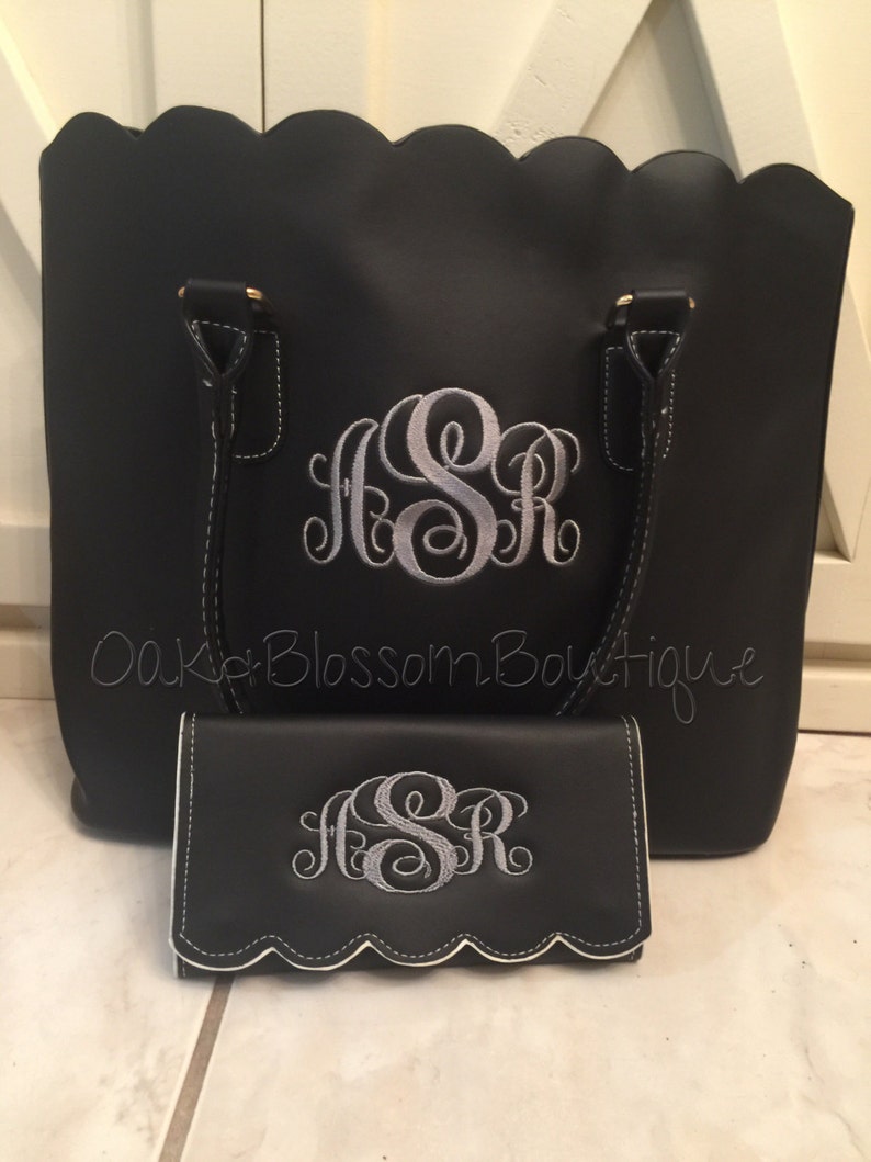 Puede incluir: Bolso tote negro y cartera a juego con bordes festoneados. Ambos art&iacute;culos presentan un monograma bordado en plata "JSR".