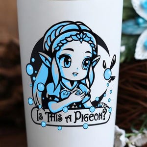 May include: White insulated tumbler with a silver rim and base. The tumbler features a cartoon graphic of a character with the text "Is This A Pigeon?" in blue and black. The background includes a blue flower arrangement.