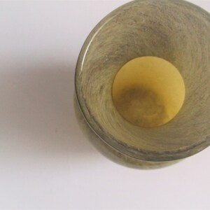 May include: A green glass vase with a textured surface and a wide opening. The vase is empty.