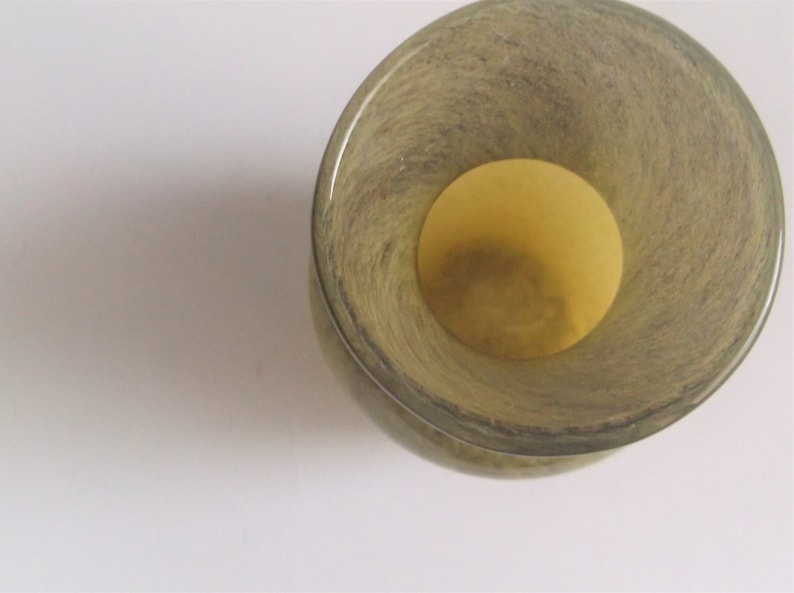 May include: A green glass vase with a textured surface and a wide opening. The vase is empty.