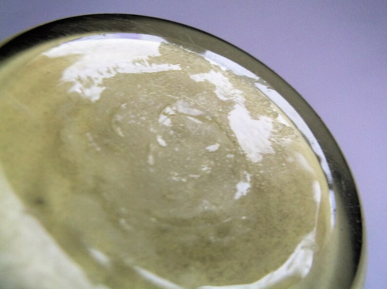 May include: Close-up of the bottom of a clear glass bottle with a textured surface.