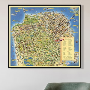 Op de afbeelding: Een vintage kaart van San Francisco, Californië, ingelijst in zwart, hangt aan een witte muur boven een groene fauteuil en een zwarte bijzettafel met een theepot en een kopje erop.