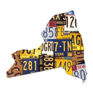 Könnte beinhalten: Eine Vintage-Silhouette des Bundesstaates New York, die aus einer Collage alter Nummernschilder besteht. Die Schilder sind in verschiedenen Farben, darunter Gelb, Blau und Rot, und zeigen Zahlen, Buchstaben und Wörter wie "New York", "World" und "Giant Leap for Mankind".