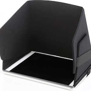 May include: Black fabric tablet sunshade with a strap to secure it to the tablet. The sunshade is designed to block glare from the sun.