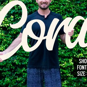 May include: White wooden sign with the name "Cora" in a cursive font. The sign is 48 inches tall. Shown: Font #1, Size: 48"
