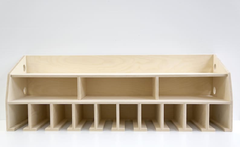 May include: A wooden wall-mounted shelf with multiple compartments. The shelf has a light wood finish and is divided into 12 sections, with a larger shelf on top.