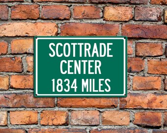 Puede incluir: Un letrero verde con texto blanco que dice "ScotTrade Center 1834 Miles" en una pared de ladrillo.