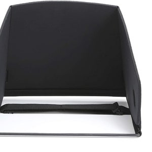 May include: A black tablet hood with a rectangular shape, designed to reduce glare. It features a fabric construction with a strap for securing and a metal frame at the base. The hood is designed to be placed over a tablet.