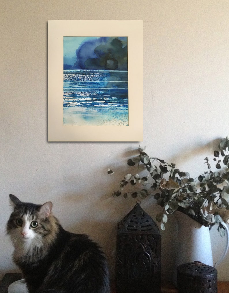 May include: A framed watercolor painting of a seascape with blue and green hues. The painting depicts a dark blue sky with a few clouds and a light blue ocean with white waves.