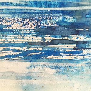 May include: Abstract watercolor painting with blue and white stripes and splatters of blue paint.
