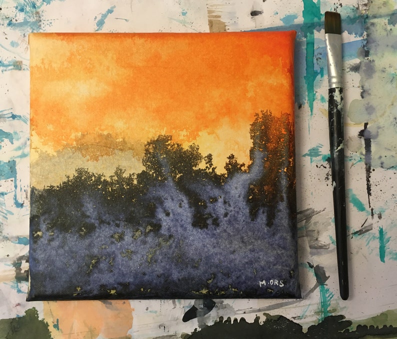 May include: A watercolor painting on canvas depicting a sunset over a forest. The sky is a vibrant orange and yellow, with wispy clouds. The trees are silhouetted against the sky, and the foreground is a dark blue and purple.