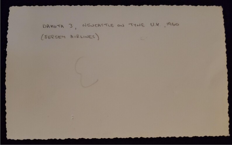 May include: A vintage photograph with a scalloped edge. Handwritten text reads "DAKOTA 3, NEWCASTLE ON TYNE U.K., 1960" and "(JERSEY AIRLINES)". The image is on a light-colored paper.
