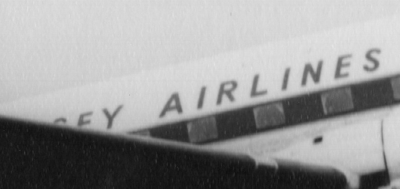 May include: Black and white image of an airplane's fuselage. The text "SEY AIRLINES" is visible in a sans-serif font. The image is slightly angled, showing a portion of the plane's wing or body.