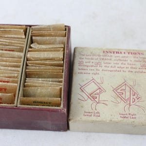May include: Vintage Duo-Gram set with instructions. The set includes a maroon box with compartments filled with small paper cards labeled "LEFT" and "RIGHT". A separate box with instructions and diagrams is also included.