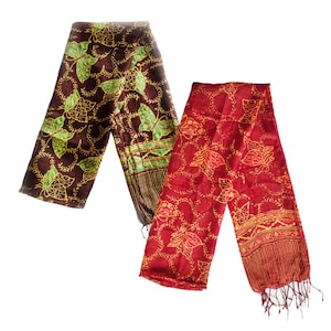May include: Two patterned scarves, one brown with green and gold accents and one red with gold accents. Both scarves feature a butterfly design.