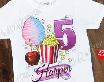 May include: White t-shirt with a purple number 5, popcorn, a candy apple, and cotton candy. The text "Harper" is written in a purple and pink font.