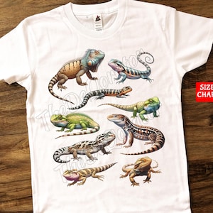 May include: White t-shirt with a colorful print of various lizards. The lizards are in different poses and have different patterns. The shirt has a crew neck and short sleeves.