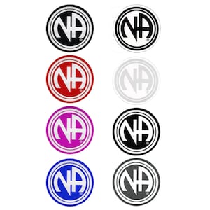 Może przedstawiać: Osiem okrągłych naklejek z logo NA w różnych kolorach. Kolory to czarny, biały, czerwony, różowy, niebieski i szary.