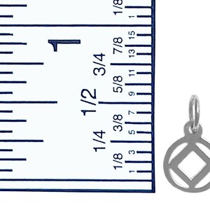 May include: A silver charm with a square inside a circle. The charm is about 3/8 inch in diameter. A ruler is in the background for size reference.