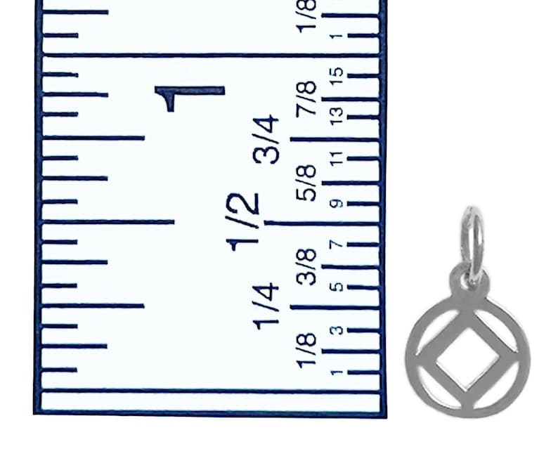 May include: A silver charm with a square inside a circle. The charm is about 3/8 inch in diameter. A ruler is in the background for size reference.