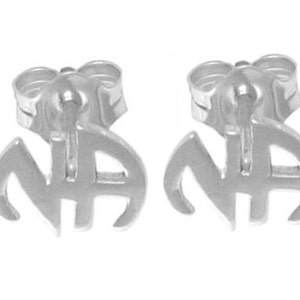 May include: A pair of silver stud earrings with the letters "NA" in a stylized font.