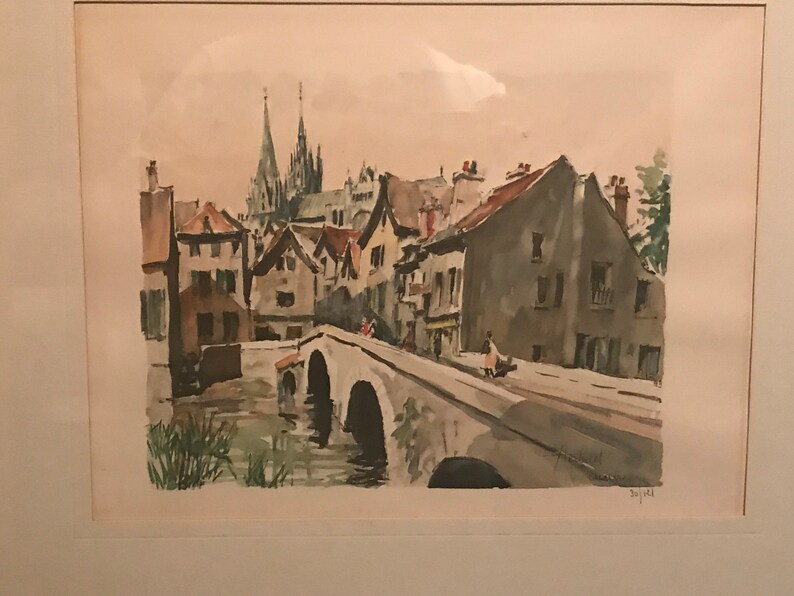 May include: A watercolor painting of a European village with a bridge over a river. The buildings are in shades of gray and brown, with a church in the background. The bridge is made of stone and has several arches. The river is a light blue color.
