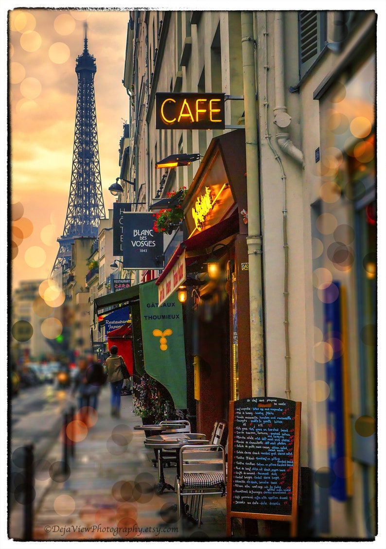 May include: A Parisian cafe with a sign reading "Cafe" in yellow letters. The cafe has a menu board with a list of food and drinks. The Eiffel Tower is visible in the background.