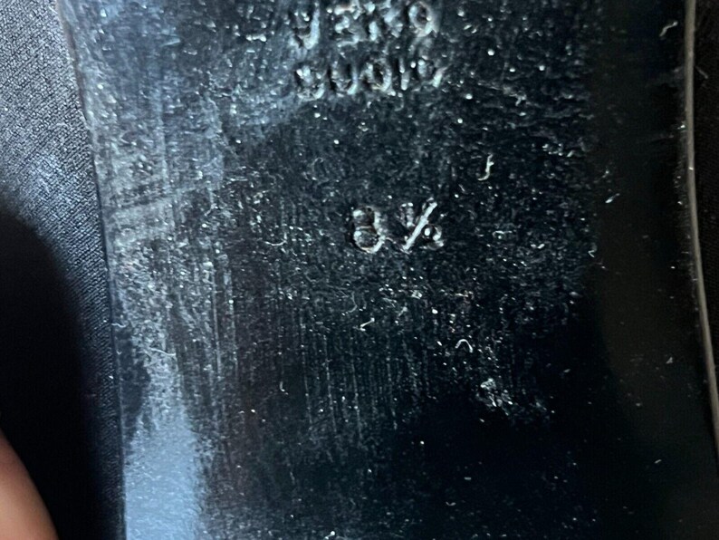 May include: Close-up of a black shoe sole with the size 8 1/2 embossed. The sole has a textured surface and the brand name "VERO CUOIO" is also visible. The shoe appears to be well-worn.