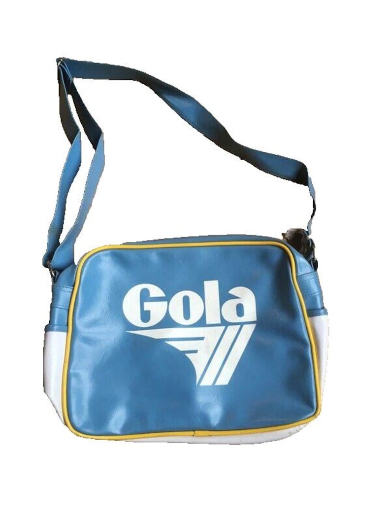 May include: A blue shoulder bag with a white and yellow trim. The bag features the white text "Gola" and a white chevron design. The bag has a blue shoulder strap.