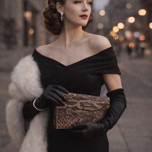 Könnte beinhalten: Eine Frau in einem schwarzen schulterfreien Kleid, schwarzen Handschuhen und einem Kunstpelzstola. Sie hält eine Clutch mit Schlangenmuster. Ihr Haar ist in einer Vintage-Hochsteckfrisur gestylt, und sie trägt Perlenohrringe und ein Armband. Der Hintergrund ist verschwommen mit Stadtlichtern.
