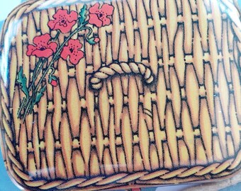 May include: A small, yellow and brown wicker basket with a rope handle. The basket is decorated with red poppies.