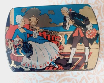 May include: A vintage tin box with a colorful illustration of a couple in period clothing. The woman is seated on a red and gold couch, while the man stands in front of her, holding a bouquet of flowers. The background is a blue sky with clouds.