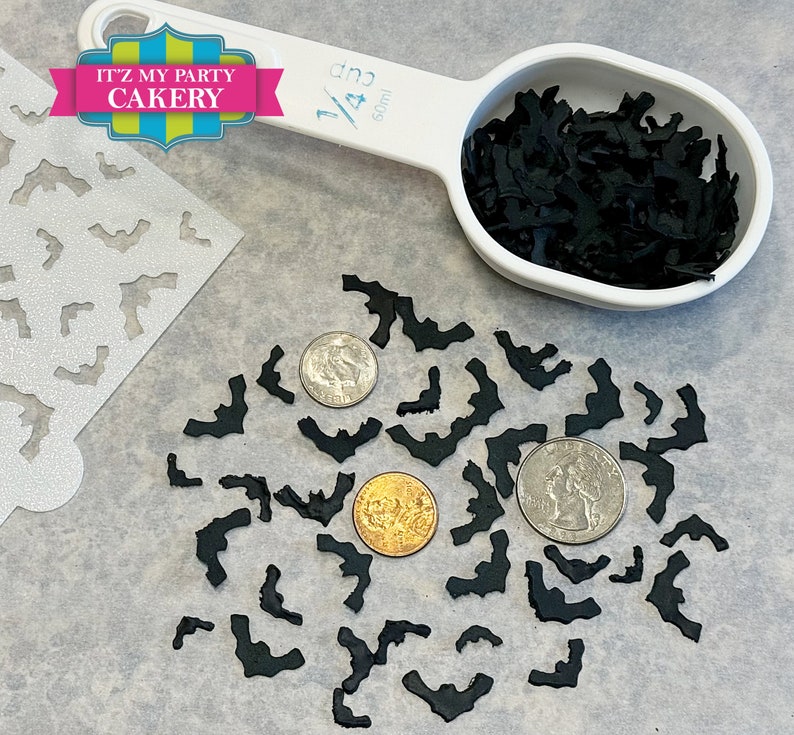May include: Black bat sprinkles for decorating cakes and cupcakes. The sprinkles are shown in a measuring cup and scattered on a table with a stencil and coins for size reference.