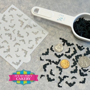 May include: A white stencil with a bat pattern, a white measuring cup filled with black bat confetti, and a pile of black bat confetti on a gray surface. The measuring cup has the text "1/4 cup" printed on it. The text "IT'Z MY PARTY CAKERY" is printed on a colorful ribbon.
